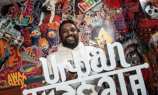 Thanujan Sivanathan präsentiert sein neues Restaurantschild vor bunter indischer Fototapeten-Kulisse. - Jörg Dieckmann - www.dieckmann-fotodesign.de Thanujan Sivanathan präsentiert sein neues Restaurantschild vor bunter indischer Fototapeten-Kulisse. - Jörg Dieckmann - www.dieckmann-fotodesign.de