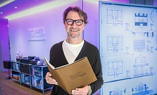 Dritte Generation: Frank Stopfel (58), hier im Eingangsbereichs seines Architekturbüros an der Schumannstraße, mit der detailreichen Chronik zum 100-jährige Bestehen des Familienunternehmens. Die verteilt er heute an besondere Gäste. - Sarah Jonek Dritte Generation: Frank Stopfel (58), hier im Eingangsbereichs seines Architekturbüros an der Schumannstraße, mit der detailreichen Chronik zum 100-jährige Bestehen des Familienunternehmens. Die verteilt er heute an besondere Gäste. - Sarah Jonek