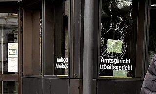 Die Scheibe, hinter der normalerweise Justizwachtmeister die Einlasskontrollen beobachten, ist seit Kurzem zerstört. - NW Die Scheibe, hinter der normalerweise Justizwachtmeister die Einlasskontrollen beobachten, ist seit Kurzem zerstört. - NW