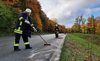 Mit Besen und Bindemittel rücken freiwillige Feuerwehrkräfte auf der Bundesstraße 239 an der Abtei Marenmünster der Ölspur zuleibe. - Madita Schellenberg Mit Besen und Bindemittel rücken freiwillige Feuerwehrkräfte auf der Bundesstraße 239 an der Abtei Marenmünster der Ölspur zuleibe. - Madita Schellenberg