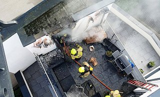 Blick aus dem Korb des Gelenkmastes auf die Brandstelle. Feuerwehrleute bei den Löscharbeiten am Abstellraum. Auf dem Balkon wurde auch Mobiliar durch die Flammen zerstört. - Feuerwehr Bad Lippringe Blick aus dem Korb des Gelenkmastes auf die Brandstelle. Feuerwehrleute bei den Löscharbeiten am Abstellraum. Auf dem Balkon wurde auch Mobiliar durch die Flammen zerstört. - Feuerwehr Bad Lippringe