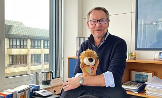 Andreas Spilker an seinem Schreibtisch, den er zum Monatsende räumt. Auf der Hand hat der Sam, den Löwen. Das ist das Maskottchen, das vom Jugendamt entwickelt wurde, um Kinder gegen sexualisierte Gewalt zu stärken. Sam steht für stark, achtsam, mutig - und Sam sagt nein. Für Spilker ist der Kinderschutz immer das zentralste Element der Arbeit im Jugendamt gewesen. - Natalie Gottwald Andreas Spilker an seinem Schreibtisch, den er zum Monatsende räumt. Auf der Hand hat der Sam, den Löwen. Das ist das Maskottchen, das vom Jugendamt entwickelt wurde, um Kinder gegen sexualisierte Gewalt zu stärken. Sam steht für stark, achtsam, mutig - und Sam sagt nein. Für Spilker ist der Kinderschutz immer das zentralste Element der Arbeit im Jugendamt gewesen. - Natalie Gottwald