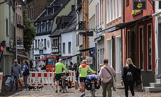 Menschen gehen durch einen Teil der Fußgängerzone in Bad Münstereifel, die noch nicht fertiggestellt ist. Knapp zwei Jahre nach der Flutkatastrophe von 2021 sind in den betroffenen Orten immer noch die Folgen sichtbar. - Oliver Berg Menschen gehen durch einen Teil der Fußgängerzone in Bad Münstereifel, die noch nicht fertiggestellt ist. Knapp zwei Jahre nach der Flutkatastrophe von 2021 sind in den betroffenen Orten immer noch die Folgen sichtbar. - Oliver Berg