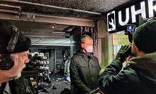 Brandermittler Philipp Schröder gibt vor dem ausgebrannten Tedi-Markt im Jahnplatz-Forum dem WDR ein Interview. Ein technischer Defekt als Ursache ließ sich ausschließen. - Jens Reichenbach Brandermittler Philipp Schröder gibt vor dem ausgebrannten Tedi-Markt im Jahnplatz-Forum dem WDR ein Interview. Ein technischer Defekt als Ursache ließ sich ausschließen. - Jens Reichenbach