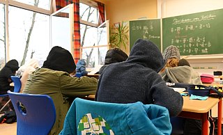 Unterricht in Coronazeiten: Vor allem am Maß der Maßnahmen, die Kinder und Jugendliche in der Pandemie getroffen haben, scheiden sich die Geister. Auf diesem Bild ist ein normaler Schultag in Osterrode im Klassenraum mit Dauerlüftung, Masken und dicken Jacken zu sehen. - picture alliance / Frank May Unterricht in Coronazeiten: Vor allem am Maß der Maßnahmen, die Kinder und Jugendliche in der Pandemie getroffen haben, scheiden sich die Geister. Auf diesem Bild ist ein normaler Schultag in Osterrode im Klassenraum mit Dauerlüftung, Masken und dicken Jacken zu sehen. - picture alliance / Frank May