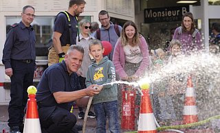 Feuerwehrmann Frank Hülshorst half den Kindern beim Zielen. Mama im Hintergrund sorgte an der Kübelspritze für den Wasserdruck. - Gerald Dunkel Feuerwehrmann Frank Hülshorst half den Kindern beim Zielen. Mama im Hintergrund sorgte an der Kübelspritze für den Wasserdruck. - Gerald Dunkel