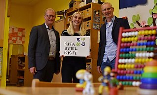 Bürgermeister Thomas Meyer (v. l.), Kita-Leiterin Celine Kucharewa und Bertram Schwade (Ev. Jugendhilfe Schweicheln) präsentieren das Logo der Kita Spielkiste. - Evangelische Jugendhilfe Schweicheln Bürgermeister Thomas Meyer (v. l.), Kita-Leiterin Celine Kucharewa und Bertram Schwade (Ev. Jugendhilfe Schweicheln) präsentieren das Logo der Kita Spielkiste. - Evangelische Jugendhilfe Schweicheln