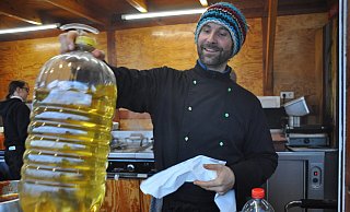 Imbiss-Besitzer Nicola Vinciguerra hält eine Flasche wertvolles Pflanzenöl in der Hand. - Simon Schulz Imbiss-Besitzer Nicola Vinciguerra hält eine Flasche wertvolles Pflanzenöl in der Hand. - Simon Schulz