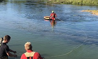 Ein angeleinter Feuerwehrmann im Überlebensabzug sichert das angetriebene Kanu. - Feuerwehr Paderborn Ein angeleinter Feuerwehrmann im Überlebensabzug sichert das angetriebene Kanu. - Feuerwehr Paderborn