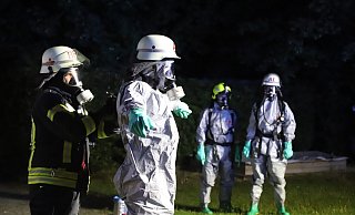Feuerwehrleute in spezieller Schutzkleidung machen sich bereit für den Einsatz. - Charlotte Mahncke Feuerwehrleute in spezieller Schutzkleidung machen sich bereit für den Einsatz. - Charlotte Mahncke