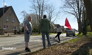 Erregte Szene: Schwungvoll tritt die Verlobte des Terrorverdächtigen Thomas N. vor dessen Haus in der Kutenhauser Straße gegen das am Boden liegende Stativ des Fernsehteams. Ihr Sohn (links) hat sich Handschuhe angezogen. - ZDF Erregte Szene: Schwungvoll tritt die Verlobte des Terrorverdächtigen Thomas N. vor dessen Haus in der Kutenhauser Straße gegen das am Boden liegende Stativ des Fernsehteams. Ihr Sohn (links) hat sich Handschuhe angezogen. - ZDF