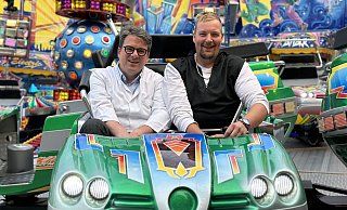 Neue Lebensfreude: Tobias Prahl genießt die Fahrt im Autoscooter auf Libori mit Chefarzt Hubert Scheuerlein. - St.-Vincenz-Kliniken Neue Lebensfreude: Tobias Prahl genießt die Fahrt im Autoscooter auf Libori mit Chefarzt Hubert Scheuerlein. - St.-Vincenz-Kliniken