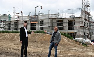 Die Geschäftsführer Matthias Bohnhorst (links) und Marcel Gehrmann stehen auf dem noch zu bebauenden Gelände und weisen auf die bereits dahinter entstehenden Mehrfamilienhäuser ihrer Projektgesellschaft Place4Life. - Britta Bohnenkamp-Schmidt Die Geschäftsführer Matthias Bohnhorst (links) und Marcel Gehrmann stehen auf dem noch zu bebauenden Gelände und weisen auf die bereits dahinter entstehenden Mehrfamilienhäuser ihrer Projektgesellschaft Place4Life. - Britta Bohnenkamp-Schmidt