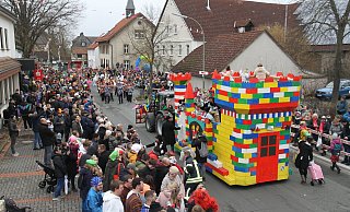 In Dreierreihen stehen die Besucher an den Straßenrändern. Vom Legoburg-Kinderprinzenwagen grüßen die Kinderprinzessinnen Laura II. und Finja I. - Johannes Büttner In Dreierreihen stehen die Besucher an den Straßenrändern. Vom Legoburg-Kinderprinzenwagen grüßen die Kinderprinzessinnen Laura II. und Finja I. - Johannes Büttner