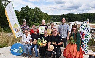 Jutta Sträter (Bioland-Hof Hartmann, vorn v. l.), Andreas Rode (Bäckerei Rode), Anna Lammert (Helle Bauer), Christian Valentin (Imkerei Familie Valentin) und LGS-Botschafterin Holli. Frederick Lüke (Umwelt-Bildungs-Initiative OWL, hinten v. l.), Claudia Koch (LGS-Geschäftsführerin), Günter Schumacher (BI Bördeland und Diemeltal), Martina Krog (Kreis Höxter) und Jan Sommer (LGS-Geschäftsführer). - Landesgartenschau Höxter Jutta Sträter (Bioland-Hof Hartmann, vorn v. l.), Andreas Rode (Bäckerei Rode), Anna Lammert (Helle Bauer), Christian Valentin (Imkerei Familie Valentin) und LGS-Botschafterin Holli. Frederick Lüke (Umwelt-Bildungs-Initiative OWL, hinten v. l.), Claudia Koch (LGS-Geschäftsführerin), Günter Schumacher (BI Bördeland und Diemeltal), Martina Krog (Kreis Höxter) und Jan Sommer (LGS-Geschäftsführer). - Landesgartenschau Höxter