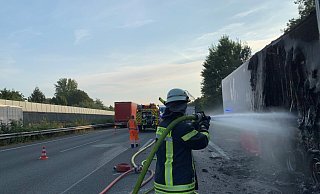 Ein Feuerwehrmann löscht nach dem Brand eines Lkw-Aufliegers noch einige Glutnester ab. Die Rauchentwicklung war nach dem Feuer weit über die Autobahn 2 hinaus zu sehen. Verletzt wurde niemand. - Daniel Hobein / Feuerwehr Bad Salzuflen Ein Feuerwehrmann löscht nach dem Brand eines Lkw-Aufliegers noch einige Glutnester ab. Die Rauchentwicklung war nach dem Feuer weit über die Autobahn 2 hinaus zu sehen. Verletzt wurde niemand. - Daniel Hobein / Feuerwehr Bad Salzuflen