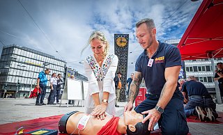 Miriam Kötter und Stefan Klaßes proben die Herzdruckmassage an einer Übungspuppe auf dem Bielefelder Jahnplatz. - Sarah Jonek Fotografie Miriam Kötter und Stefan Klaßes proben die Herzdruckmassage an einer Übungspuppe auf dem Bielefelder Jahnplatz. - Sarah Jonek Fotografie