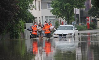 Anfang Juni hatten auch Bünde und Enger mit Wassermassen zu kämpfen. Feuerwehrmänner begleiten eine Frau durch das Hochwasser an der Engerstraße in Bünde. - Florian Weyand Anfang Juni hatten auch Bünde und Enger mit Wassermassen zu kämpfen. Feuerwehrmänner begleiten eine Frau durch das Hochwasser an der Engerstraße in Bünde. - Florian Weyand