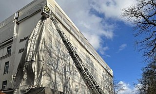 Mittels Drehleiter entfernte die Feuerwehr die herabstürzende Plane von der Fassade des Königshofes. - Feuerwehr Bad Oeynhausen Mittels Drehleiter entfernte die Feuerwehr die herabstürzende Plane von der Fassade des Königshofes. - Feuerwehr Bad Oeynhausen