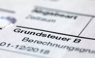 Ein Abgabenbescheid für die Entrichtung der Grundsteuer liegt auf einem Schreibtisch. - Jens Büttner Ein Abgabenbescheid für die Entrichtung der Grundsteuer liegt auf einem Schreibtisch. - Jens Büttner