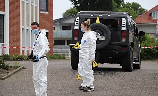 Zwei Spezialisten der Spurensicherung vor dem beschossenen Geländewagen. Zwei Einschüsse am Heck sind erkennbar, doch es soll mehrere Treffer geben. - Charlotte Mahncke Zwei Spezialisten der Spurensicherung vor dem beschossenen Geländewagen. Zwei Einschüsse am Heck sind erkennbar, doch es soll mehrere Treffer geben. - Charlotte Mahncke