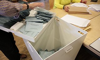Die blauen Stimmzettelumschläge landen in der Wahlurne. - Dieter Scholz Die blauen Stimmzettelumschläge landen in der Wahlurne. - Dieter Scholz