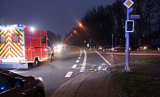 Das Fahrrad des 40-Jährigen blieb am Rand der Fahrbahn auf dem Boden liegen. Ein Rettungswagen steht auf der Kreuzung. - Polizei Minden-Lübbecke Das Fahrrad des 40-Jährigen blieb am Rand der Fahrbahn auf dem Boden liegen. Ein Rettungswagen steht auf der Kreuzung. - Polizei Minden-Lübbecke