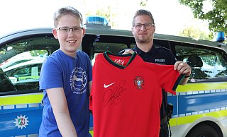 Marlon Westerbarkei (13) freut sich total, dass Polizeihauptkommissar Dennis Heitmann sein verloren geglaubtes Trikot gefunden hat. - Celina Allard Marlon Westerbarkei (13) freut sich total, dass Polizeihauptkommissar Dennis Heitmann sein verloren geglaubtes Trikot gefunden hat. - Celina Allard