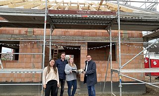 Bürgermeister Lars Bökenkröger (r.) und Valeria Usatschov von der Wirtschaftsförderung (l.) übergeben ein Geschenk zur Einweihung des Rohbaus an die Hausherren Karine Pfeifer und Benedikt Mertens. - Elke Niedringhaus-Haasper Bürgermeister Lars Bökenkröger (r.) und Valeria Usatschov von der Wirtschaftsförderung (l.) übergeben ein Geschenk zur Einweihung des Rohbaus an die Hausherren Karine Pfeifer und Benedikt Mertens. - Elke Niedringhaus-Haasper
