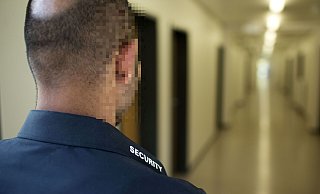 Ein Mitarbeiter einer Sicherheitsfirma (Symbolfoto) auf dem Gang einer zu bewachenden Einrichtung. - picture alliance / photothek Ein Mitarbeiter einer Sicherheitsfirma (Symbolfoto) auf dem Gang einer zu bewachenden Einrichtung. - picture alliance / photothek