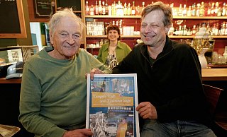 Die Autoren Willibald A. Bernert und Frank Tippelt präsentieren das Buchcover von "Kneipen, Kult und Kümmerlinge". Im Hintergrund macht Mokkaklatsch-Thekenkraft Aileen das Foto deutlich hübscher. - Peter Unger Die Autoren Willibald A. Bernert und Frank Tippelt präsentieren das Buchcover von "Kneipen, Kult und Kümmerlinge". Im Hintergrund macht Mokkaklatsch-Thekenkraft Aileen das Foto deutlich hübscher. - Peter Unger