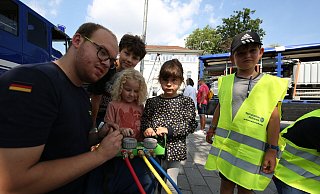 THW-Mann Daniel Hills hilft Johanna (4) und Alva (4) beim Steuern von aufblasbaren Hebekissen. Mika (6, rechts) und Finn (12, dahinter) sind danach dran. - Gerald Dunkel THW-Mann Daniel Hills hilft Johanna (4) und Alva (4) beim Steuern von aufblasbaren Hebekissen. Mika (6, rechts) und Finn (12, dahinter) sind danach dran. - Gerald Dunkel