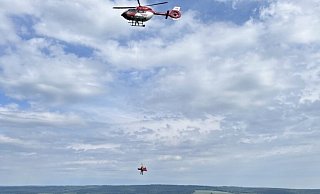 Der Rettungshubschrauber aus Dortmund hilft bei der Bergung des verletzten Gleitschirmfliegers. - Polizei Kreis Höxter Der Rettungshubschrauber aus Dortmund hilft bei der Bergung des verletzten Gleitschirmfliegers. - Polizei Kreis Höxter