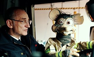 Robert Husemann von Paderborner Puppenspiele und "Rudi Ratte" zeigen den Kindern die Paderborner Feuerwache per Videopodcast. - Feuerwehr Paderborn Robert Husemann von Paderborner Puppenspiele und "Rudi Ratte" zeigen den Kindern die Paderborner Feuerwache per Videopodcast. - Feuerwehr Paderborn