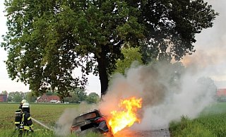 Feuerwehrleute löschen das in Flammen stehende Auto der 18-Jährigen aus Espelkamp. - Polizei Minden-Lübbecke Feuerwehrleute löschen das in Flammen stehende Auto der 18-Jährigen aus Espelkamp. - Polizei Minden-Lübbecke