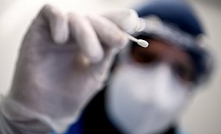 Ein Arzt hält ein Teststäbchen für einen Corona-Test in der Hand. Aktuell pendeln sich die Inzidenzen auf einem hohen Niveau ein, die kostenlosen Bürgertests gibt es aber nur bis Ende Juni. - Britta Pedersen Ein Arzt hält ein Teststäbchen für einen Corona-Test in der Hand. Aktuell pendeln sich die Inzidenzen auf einem hohen Niveau ein, die kostenlosen Bürgertests gibt es aber nur bis Ende Juni. - Britta Pedersen