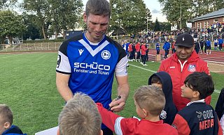 Arminia-Urgestein Fabian Klos gibt einem kleinen Herringhausen-Fan ein Autogramm. - Andreas Gerth Arminia-Urgestein Fabian Klos gibt einem kleinen Herringhausen-Fan ein Autogramm. - Andreas Gerth