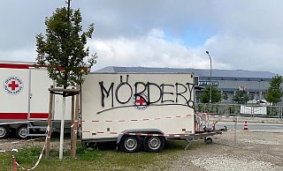 "Mörder" prangt in Großbuchstaben auf zwei Anhängern an der Coronateststelle des DRK-Ortsvereins Schloß Neuhaus. - DRK-Ortsverein Schloß Neuhaus "Mörder" prangt in Großbuchstaben auf zwei Anhängern an der Coronateststelle des DRK-Ortsvereins Schloß Neuhaus. - DRK-Ortsverein Schloß Neuhaus