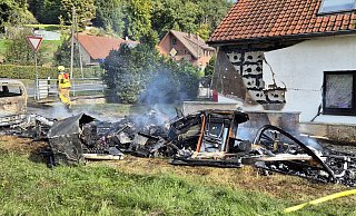 Vom Wohnwagen sind nur verkohlte Reste übrig geblieben. Es braucht viel Fantasie, um herauszufinden, welche Funktion sie einst hatten. - Feuerwehr Bad Oeynhausen Vom Wohnwagen sind nur verkohlte Reste übrig geblieben. Es braucht viel Fantasie, um herauszufinden, welche Funktion sie einst hatten. - Feuerwehr Bad Oeynhausen