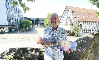 Am Donnerstagabend startet die Bünder Sommerkultur wieder auf dem Rathausplatz im Hintergrund. Ansonsten hält Dirk Kaiser das prall gefüllte Veranstaltungsprogramm für Universum und Stadtgarten bis Februar 2025 in der Hand. - Natalie Gottwald Am Donnerstagabend startet die Bünder Sommerkultur wieder auf dem Rathausplatz im Hintergrund. Ansonsten hält Dirk Kaiser das prall gefüllte Veranstaltungsprogramm für Universum und Stadtgarten bis Februar 2025 in der Hand. - Natalie Gottwald