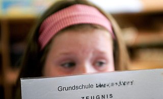 Eine Schülerin betrachtet in einer Grundschule ihr Zeugnis. Es scheint böse Überraschungen zu geben. - Michael Löwa/dpa Eine Schülerin betrachtet in einer Grundschule ihr Zeugnis. Es scheint böse Überraschungen zu geben. - Michael Löwa/dpa