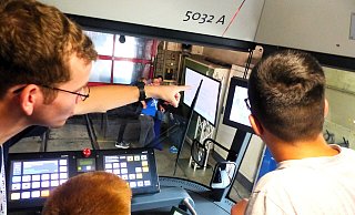 Elektriker Lukas Kohring zeigt Lenn (14) und Tim (15) wofür all die Schalter und Bildschirme im Bahn Cockpit da sind. Foto: Jan Moshage - Jan Moshage Elektriker Lukas Kohring zeigt Lenn (14) und Tim (15) wofür all die Schalter und Bildschirme im Bahn Cockpit da sind. Foto: Jan Moshage - Jan Moshage