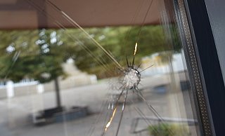 Kreisrunde Löcher in der Eingangstür der Grundschule Neesen: Auf die Glasscheibe ist möglicherweise geschossen worden. - MT-Foto: Dirk Haunhorst Kreisrunde Löcher in der Eingangstür der Grundschule Neesen: Auf die Glasscheibe ist möglicherweise geschossen worden. - MT-Foto: Dirk Haunhorst