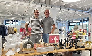 Timo Häberle, Leitung der Factory-Outlets bei Brax (links) und Geschäftsführer und Unternehmenssprecher Marc Freyberg im Herforder Outlet Im Kleinen Felde. Auf dem Verkaufstisch vor ihnen sind Artikel aus dem Bereich "Home & Living", also Dekorationsartikel für Zuhause, zu sehen. Auch dieses Sortiment ergänzt nun bereits das Kleidungsangebot. - Natalie Gottwald Timo Häberle, Leitung der Factory-Outlets bei Brax (links) und Geschäftsführer und Unternehmenssprecher Marc Freyberg im Herforder Outlet Im Kleinen Felde. Auf dem Verkaufstisch vor ihnen sind Artikel aus dem Bereich "Home & Living", also Dekorationsartikel für Zuhause, zu sehen. Auch dieses Sortiment ergänzt nun bereits das Kleidungsangebot. - Natalie Gottwald