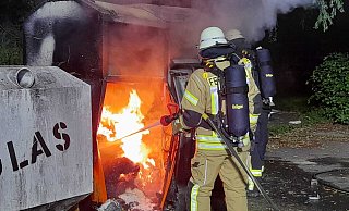 Flammen schlagen aus den beiden Altkleidercontainern, während Kräfte der Feuerwehr das Löschen starten. - Ralf Scholle Flammen schlagen aus den beiden Altkleidercontainern, während Kräfte der Feuerwehr das Löschen starten. - Ralf Scholle