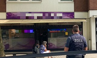 Ein Ermittler des Zolls vor dem Studio. Kollegen des Beamten überprüfen die Beschäftigten. - Jobst Lüdeking Ein Ermittler des Zolls vor dem Studio. Kollegen des Beamten überprüfen die Beschäftigten. - Jobst Lüdeking