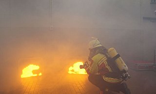 Wenn Rauch aus einer Nebelmaschine dazu kommt, wirken die digitalen Flammen realistisch. Der Feuerwehrmann zielt mit einem Laser auf das den Bildschirm. - Jobst Lüdeking Wenn Rauch aus einer Nebelmaschine dazu kommt, wirken die digitalen Flammen realistisch. Der Feuerwehrmann zielt mit einem Laser auf das den Bildschirm. - Jobst Lüdeking