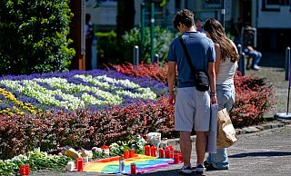 24.08.2024, Nordrhein-Westfalen, Solingen: Nach der Messerattacke auf dem Solinger Stadtfest legen Menschen in der Nähe des Tatortes Blumen neben einer Regenbogenflagge nieder. Bei einer Attacke auf der 650-Jahr-Feier der Stadt Solingen hat es Todesopfer und Verletzte gegeben. Foto: Henning Kaiser/dpa +++ dpa-Bildfunk +++ - Henning Kaiser 24.08.2024, Nordrhein-Westfalen, Solingen: Nach der Messerattacke auf dem Solinger Stadtfest legen Menschen in der Nähe des Tatortes Blumen neben einer Regenbogenflagge nieder. Bei einer Attacke auf der 650-Jahr-Feier der Stadt Solingen hat es Todesopfer und Verletzte gegeben. Foto: Henning Kaiser/dpa +++ dpa-Bildfunk +++ - Henning Kaiser