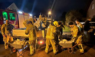 Einsatzkräfte der Feuerwehr Bad Lippspringe und Mitarbeiter des städtischen Bauhofs laden am Mittelgraben gefüllte Sandsäcke ab. - Ralph Meyer Einsatzkräfte der Feuerwehr Bad Lippspringe und Mitarbeiter des städtischen Bauhofs laden am Mittelgraben gefüllte Sandsäcke ab. - Ralph Meyer