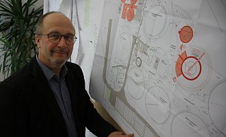 Technischer Leiter Helmut Schmitz hat im Büro die alten Pläne für den Umbau aufgehängt. Die roten Bereiche wurden aus den aktuellen Planungen herausgenommen. Die blaue Linie zeichnet das Bemessungshochwasser nach. Foto: Dieter Scholz - Dieter Scholz Technischer Leiter Helmut Schmitz hat im Büro die alten Pläne für den Umbau aufgehängt. Die roten Bereiche wurden aus den aktuellen Planungen herausgenommen. Die blaue Linie zeichnet das Bemessungshochwasser nach. Foto: Dieter Scholz - Dieter Scholz